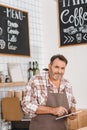 mature happy bartender using tablet