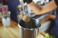 Process of bartending in bar,pouring a tablespoon of brown sugar in shaker