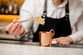 Bartender in white shirt adding two slices of ginger into a cup Royalty Free Stock Photo