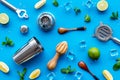 Bartender work desk with equipment and cocktail ingredietns Shaker, lime, ice on blue background top-down pattern Royalty Free Stock Photo