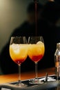 On the bartenders table are two glasses of orange and red cocktails into which the drink is poured. Orange juice, alcohol. On a Royalty Free Stock Photo