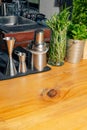 Bartending tools with rosemary and mint on wooden counter in bright kitchen setting Royalty Free Stock Photo
