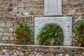 Bas-relief and flowers, courtyard of the Greek Orthodox Wedding Church in Cana, Israel. Royalty Free Stock Photo