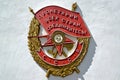 Bas-relief of the Order of the Red Banner on the facade of the building. Russian text - proletarians of all countries, unite Royalty Free Stock Photo