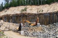 Basalt mining. Yellow excavators in a basalt quarry near the forest Royalty Free Stock Photo