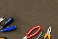 Base angle frame industrial design base screwdriver nippers red yellow pliers set of tools on a brown background Royalty Free Stock Photo