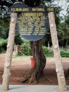 The base camp sign post. guides porters and sherpas carry heavy sacks as they ascend mount kilimanjaro