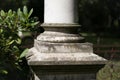 Base of a column, pillar closeup with garden background