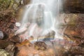 Base of a powerful waterfall splashing on the rock creating a rainbow Royalty Free Stock Photo