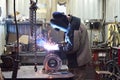 The base for the valve is mounted on the iron table at the factory and the worker welds with a welding machine. Sparks Royalty Free Stock Photo