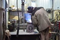 The base for the valve is mounted on the iron table at the factory and the worker welds with a welding machine. Sparks Royalty Free Stock Photo