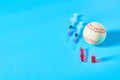 Baseball ball near syringe and ampoule on blue background. Concept of doping in professional sport Royalty Free Stock Photo