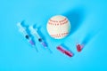 Baseball ball near syringe and ampoule on blue background. Concept of doping in professional sport Royalty Free Stock Photo