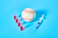 Baseball ball near syringe and ampoule on blue background. Concept of doping in professional sport Royalty Free Stock Photo