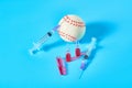 Baseball ball near syringe and ampoule on blue background. Concept of doping in professional sport Royalty Free Stock Photo