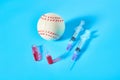 Baseball ball near syringe and ampoule on blue background. Concept of doping in professional sport Royalty Free Stock Photo