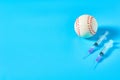 Baseball ball near syringe on blue background. Concept of doping in professional sport Royalty Free Stock Photo