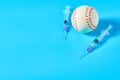 Baseball ball near syringe on blue background. Concept of doping in professional sport Royalty Free Stock Photo