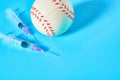 Baseball ball near syringe on blue background. Concept of doping in professional sport Royalty Free Stock Photo