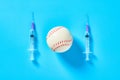 Baseball ball near syringe on blue background. Concept of doping in professional sport Royalty Free Stock Photo