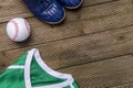 Baseball ball, shirts and shoes on old wooden background. Team sport Royalty Free Stock Photo