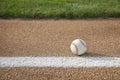 Baseball on base path with grass infield