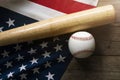 Baseball and baseball bat with American flag in the background Royalty Free Stock Photo