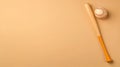 Baseball Bat and Ball on Solid Background A baseball bat and ball placed on a solid light brown background perfect for sports Royalty Free Stock Photo