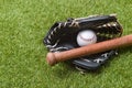 Baseball bat, glove and ball on green grass field. Sport theme background with copy space for text and advertisment Royalty Free Stock Photo
