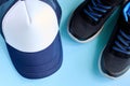 Baseball cap and sneakers on blue background composition Royalty Free Stock Photo