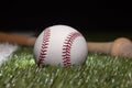 Baseball close up low angle with bat on grass field and black background Royalty Free Stock Photo