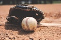 Baseball on field with glove close up in dirt. Royalty Free Stock Photo