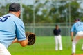 Baseball game, first baseman is getting ready to catch a ball from a pitcher, base coach in the background Royalty Free Stock Photo