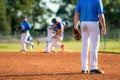 Baseball game, infielder on the third base is watching the close play on the first base