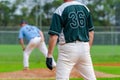 Baseball game, runner on the first base is watching the pitcher and getting ready to steal the second Royalty Free Stock Photo