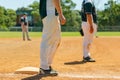 Baseball game, runner on the third base is watching the pitcher and getting ready to run to home plate and score Royalty Free Stock Photo