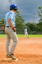 Baseball game, runner on the third base is watching the pitcher and getting ready to run to home plate and score Royalty Free Stock Photo