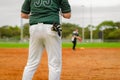 Baseball game, runner on the third base is watching the play and getting ready to run to home plate and score Royalty Free Stock Photo