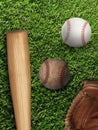 Baseball, glove, ball and bat on field