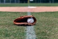 Baseball glove and ball on foul line Royalty Free Stock Photo