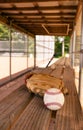 Baseball with glove on dugout bench with blurred background Royalty Free Stock Photo