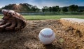 Baseball and glove on pitcher`s mound in early morning