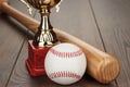 Golden trophy cup and baseball bat and ball on wooden table Royalty Free Stock Photo