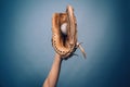 Baseball leather glove with white ball on woman hand on dark blue background Royalty Free Stock Photo