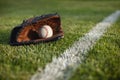 Baseball mitt and ball on field with white line Royalty Free Stock Photo