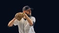 Baseball pitcher holding ball and glove in ready position on dark background. Royalty Free Stock Photo