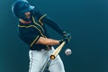 Baseball player with bat taking a swing on grand arena. Ballplayer on dark background in action. Royalty Free Stock Photo