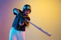 Baseball player, pitcher in a black uniform practicing on gradient background in neon light Royalty Free Stock Photo