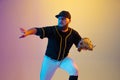 Baseball player, pitcher in a black uniform practicing on gradient background in neon light Royalty Free Stock Photo