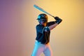 Baseball player, pitcher in a black uniform practicing on gradient background in neon light Royalty Free Stock Photo